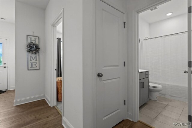 7217 Leire Ln, Chesterfield, VA 23832 - bathroom featuring vanity, baseboards, wood finished floors, toilet, and shower / bath combo with shower curtain