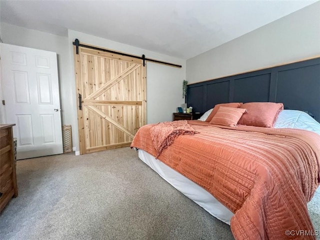 bedroom featuring a barn door and carpet