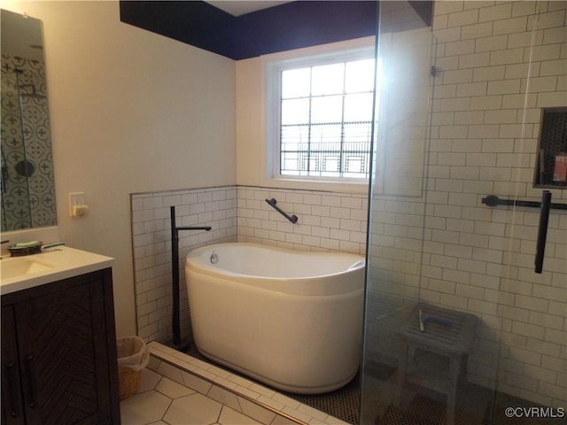 8304 Elizabeth Ann Dr, Hanover, VA 23111 - bathroom with tile patterned floors, tile walls, a tub to relax in, and vanity