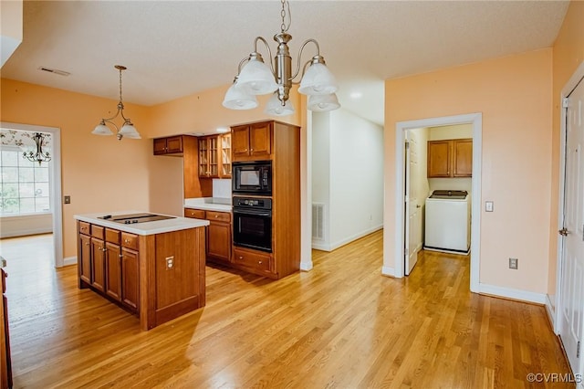 240 Lighthouse Pointe, North Prince George, VA 23860 - kitchen with washer / dryer, black appliances, brown cabinets, a chandelier, and light wood-type flooring