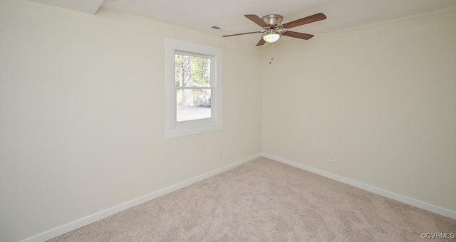 spare room with baseboards, visible vents, light colored carpet, and ceiling fan