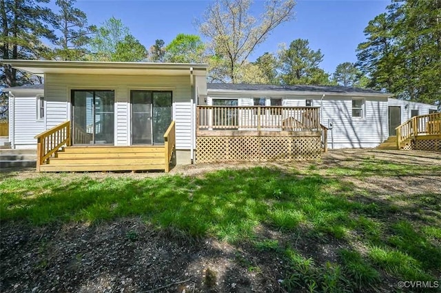 back of property with a lawn and a wooden deck