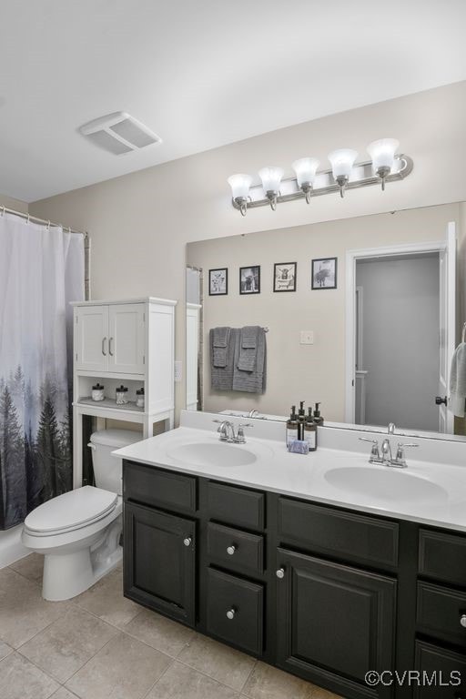 full bathroom featuring double vanity, a sink, and tile patterned flooring