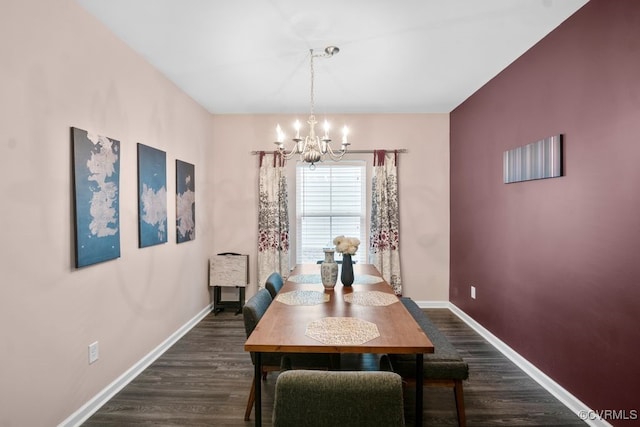 dining area with baseboards, an inviting chandelier, and dark wood-type flooring