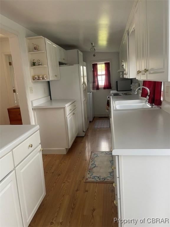 211 Taylor Ave, Urbanna, VA 23175 - kitchen with white fridge with ice dispenser, a sink, light countertops, light wood-style floors, and white cabinetry