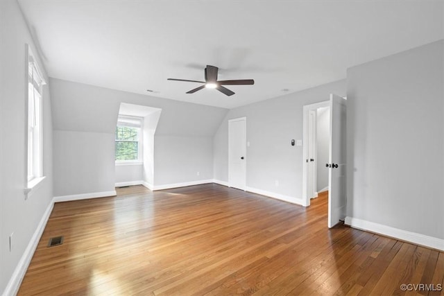 bonus room with hardwood / wood-style flooring, ceiling fan, baseboards, and visible vents