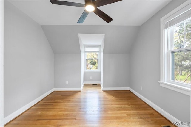bonus room with lofted ceiling, plenty of natural light, light wood-type flooring, and ceiling fan