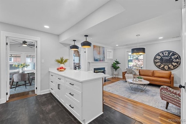 kitchen with a peninsula, light countertops, baseboards, and white cabinetry