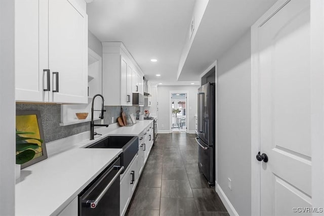 kitchen with white cabinets, high quality fridge, dishwashing machine, a sink, and baseboards