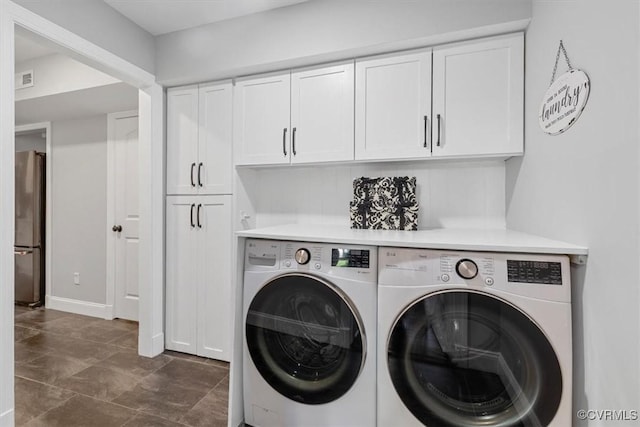 laundry room featuring baseboards, visible vents, washer and dryer, and cabinet space