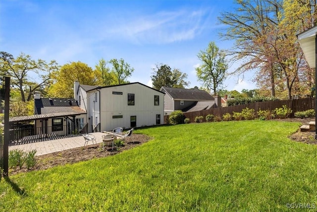 back of property with a yard, a patio area, and fence