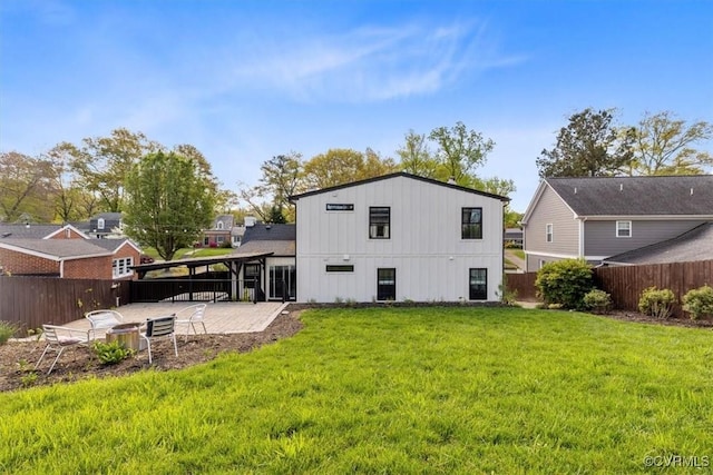 rear view of house featuring a fenced backyard, a patio area, and a lawn