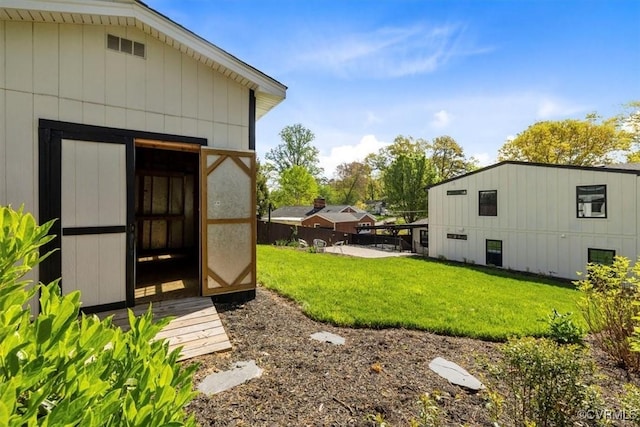 view of yard featuring an outdoor structure, fence, and a storage unit