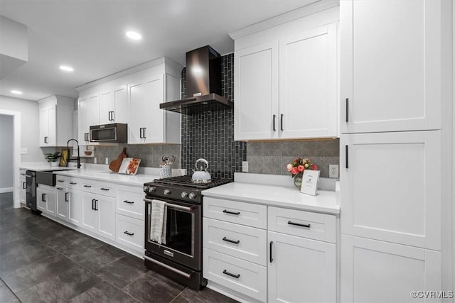 kitchen with light countertops, a sink, decorative backsplash, wall chimney range hood, and stainless steel gas stove