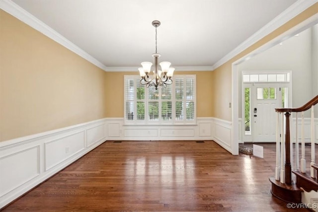 unfurnished dining area featuring an inviting chandelier, crown molding, and a healthy amount of sunlight
