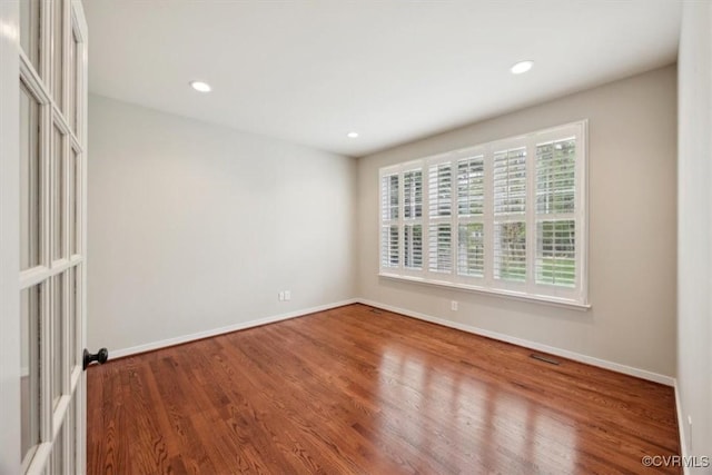 empty room with recessed lighting, baseboards, and wood finished floors