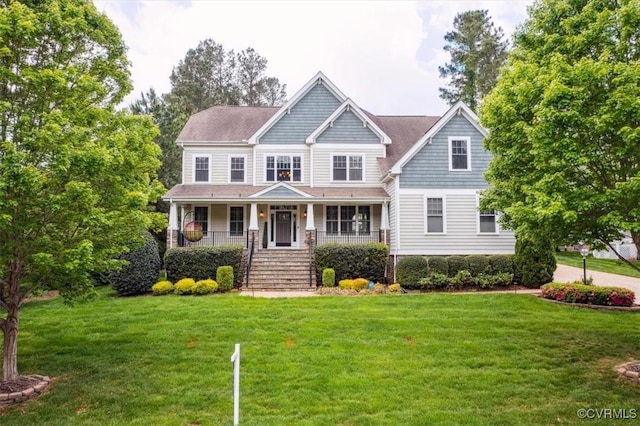 craftsman-style home featuring covered porch, stairs, and a front yard