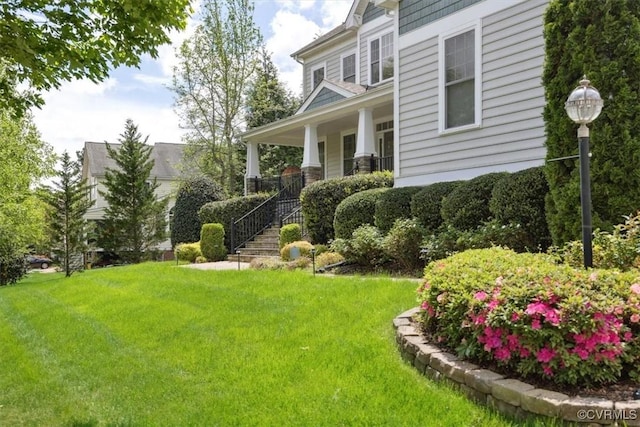view of yard with covered porch and stairs