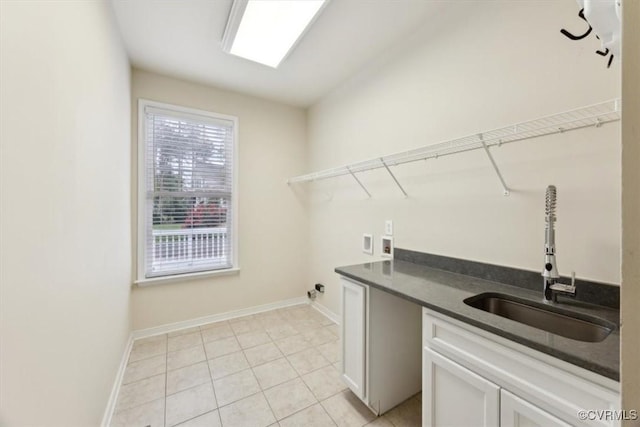 washroom with baseboards, hookup for a washing machine, a sink, cabinet space, and light tile patterned floors