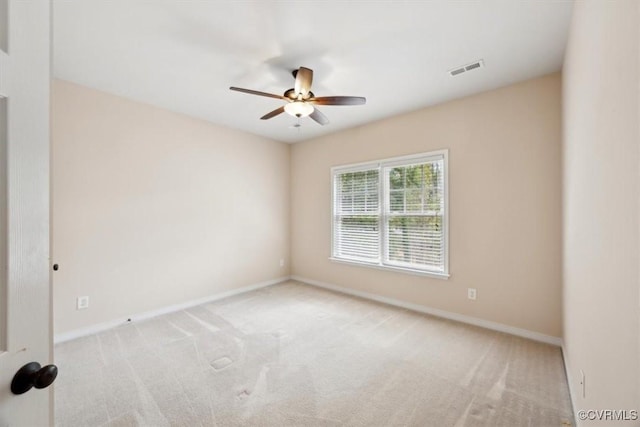 carpeted spare room with a ceiling fan, baseboards, and visible vents