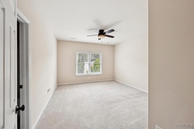 carpeted spare room with baseboards and ceiling fan