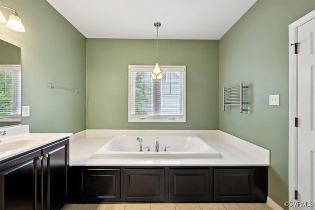 bathroom featuring tile patterned flooring, a bath, and vanity