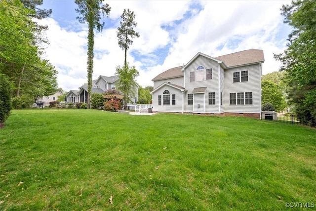 back of house with a lawn, fence, and crawl space