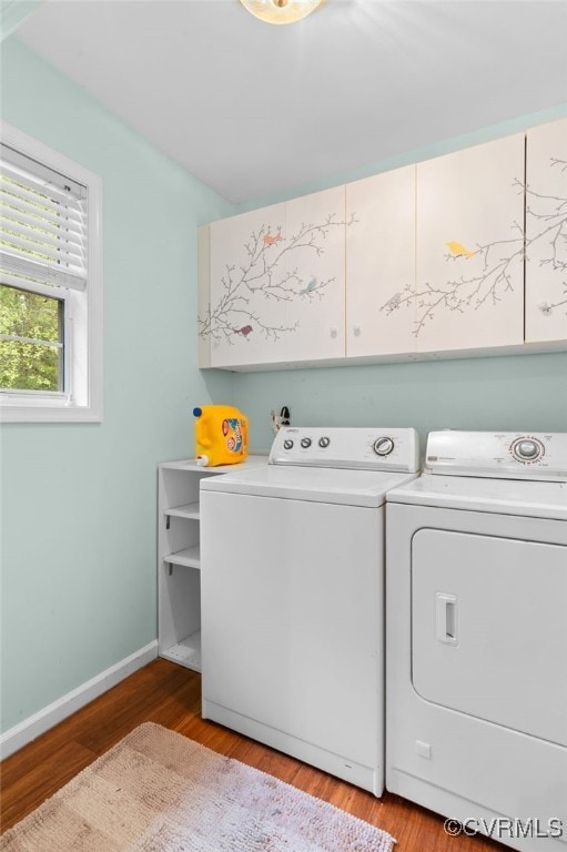 laundry room with cabinet space, independent washer and dryer, baseboards, and light wood-style flooring