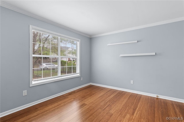 unfurnished room with crown molding, baseboards, and wood finished floors