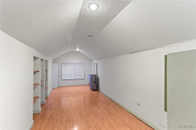 additional living space featuring wood finished floors and lofted ceiling