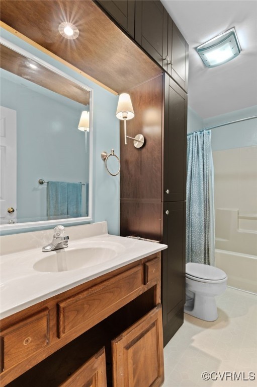 bathroom featuring toilet, vanity, and shower / bath combo with shower curtain