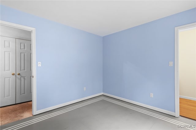 spare room with concrete floors and baseboards