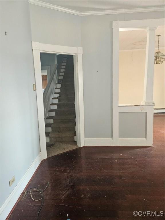 spare room with crown molding, wood finished floors, and baseboards
