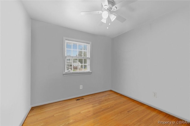 spare room featuring visible vents, baseboards, light wood finished floors, and a ceiling fan