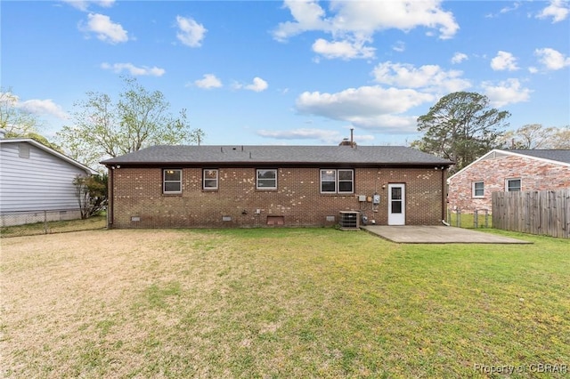 back of property with brick siding, a fenced backyard, a lawn, and a patio area