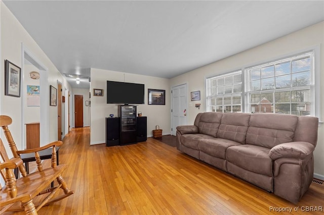 living area featuring baseboards and light wood-style floors
