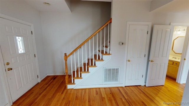 entrance foyer featuring visible vents, light wood finished floors, and stairway