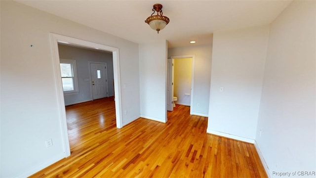 empty room featuring light wood-style flooring, baseboards, and recessed lighting