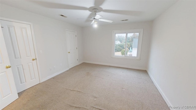 spare room featuring visible vents, baseboards, a ceiling fan, and carpet floors