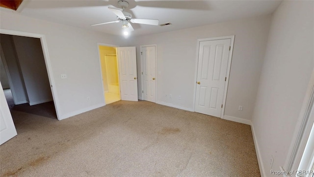 unfurnished bedroom featuring two closets, visible vents, baseboards, and carpet