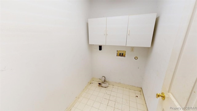 clothes washing area featuring washer hookup, baseboards, and cabinet space
