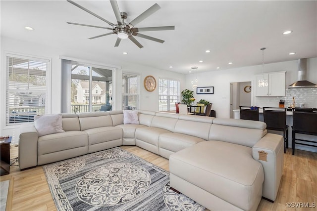 living room with light wood-style flooring, ceiling fan, and recessed lighting