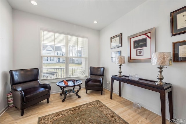 sitting room with baseboards, recessed lighting, and wood finished floors