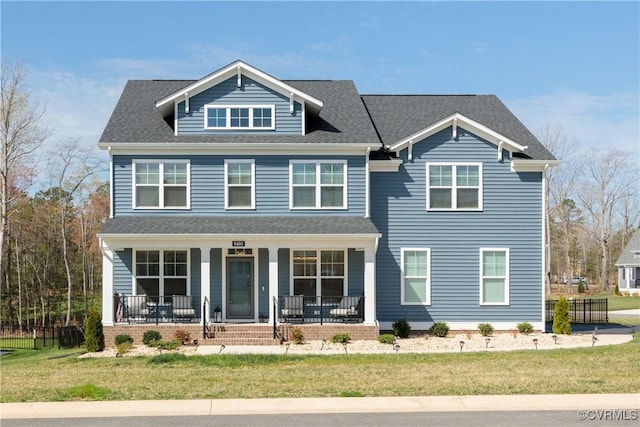 view of front of property with roof with shingles, fence, a front lawn, and covered porch