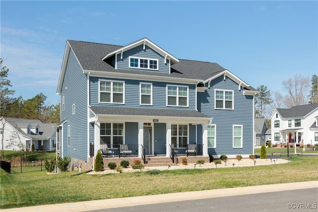 view of front facade with a front yard, fence, and covered porch