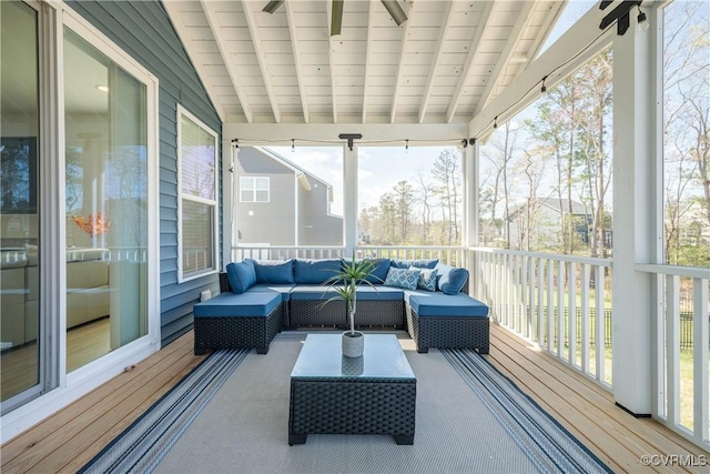 sunroom featuring beam ceiling and an outdoor hangout area