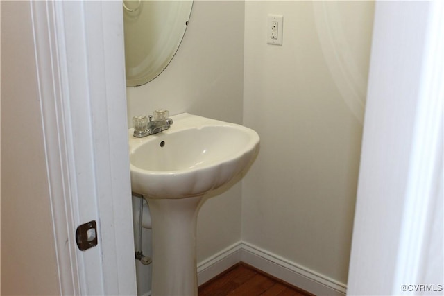 bathroom with baseboards and wood finished floors