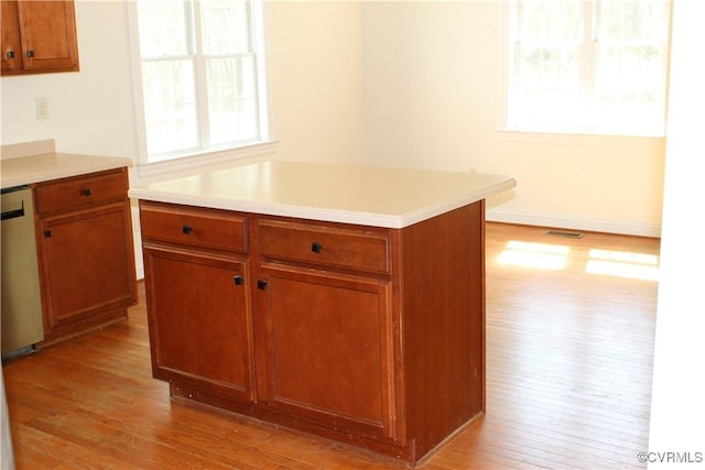 kitchen featuring light countertops, visible vents, light wood-style flooring, and brown cabinets