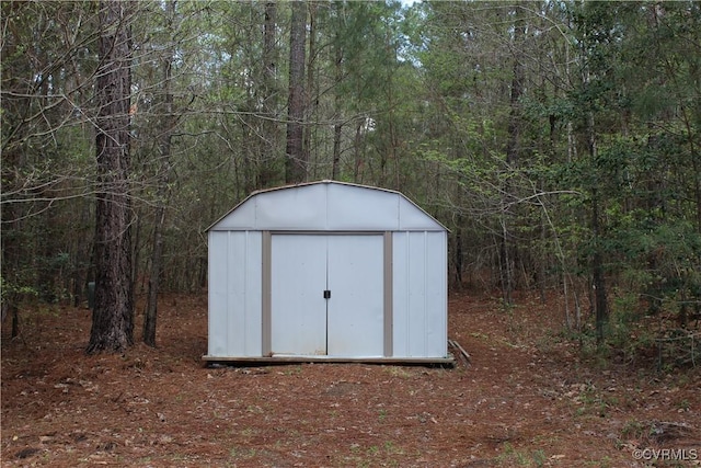 view of shed with a wooded view