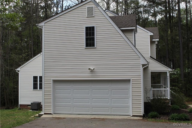 view of home's exterior featuring a shingled roof, a garage, aphalt driveway, and central air condition unit